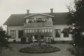 Familjen samlad på balkong och framför verandan 1930-tal