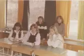 Fem elever som befinner sig i ett klassrum, Brattåsskolan 1970- till 80-tal. Genom fönstren ses att det är vinter.