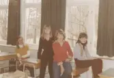 Fyra elever som befinner sig i ett klassrum, Brattåsskolan 1970- till 80-tal. Genom fönstren ses att det är vinter.