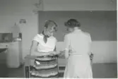 Två kvinnliga lärarinnor står vända mot varandra, Kålleredskolan 1960-tal. I bakgrunden ses 