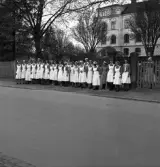 Gymnastikuppvisningen, 25/5 1941. 
Kökspersonalen (?), lottor (?), vid Dövstumskolan har ställt upp sig för att titta på de kvinnliga gymnasterna, när de tågar förbi.