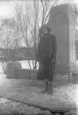 Kvinna i svart dräkt vid minnessten, 1920-tal