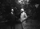 Två män vid en park eller trädgård. Enligt anteckning 
