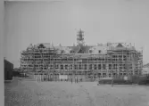 Byggnation av Stadshotellet/Stadshuset i Varberg. Byggnadsställningar runt hela huset och takspiran.