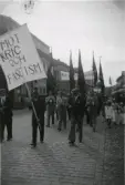 1:a majdemonstration, man tågar med orkester på Torggatan på väg upp mot Påskbergsskogen. Mannen längst fram t v är Charlie (?) Jalmarsson, kallad Chaplin. Han arbetade på Monark.