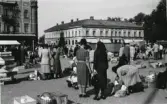 Varbergs torg med torghandel efter 1937. Vy mot Lundquistska huset i kv Brunnsparken och till vänster hörnet av Stadshuset/Stadshotellet. Mellan husen går Torggatan.