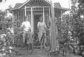 Två unga damer med cyklar vid kolonistuga i Örebro, 1920-tal