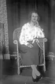 Porträtt av ung dam sittande i korgstol, 1920-tal
