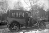 En chaufför vid sin bil som används som taxi i Örebro, 1920-tal