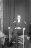 Porträtt av ung man i korgstol, 1920-tal
