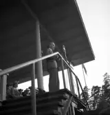 Svenska Flaggans dag, 6/6 1941. En man i kostym, talar i mikrofon från hedersläktaren på Värendsvallen.