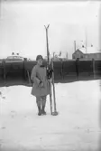 Vinterklädd kvinna håller skidor och stavar, 1920-tal