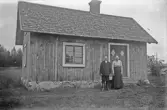 Äldre par utanför ett torp, 1920-tal