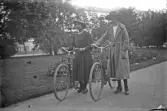 Två damer med cyklar i park, 1920-tal