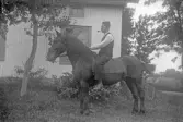 Piprökande rider bakbacka på en häst, 1920-tal