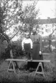 Kvinna med liten pojke på bänk. 1920-tal