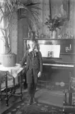 Ung man i kostym med halsrosett vid piano, 1920-tal