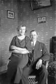 Kärleksfullt par sitter i en korgstol i hemmet, 1920-tal