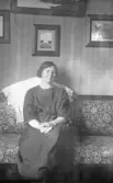 Ung kvinna i soffa i hemmet, 1920-tal