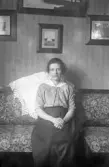Porträtt av kvinna i soffa i hemmet, 1920-tal