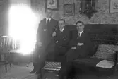 Tre herrar sitter i soffan med ett dragspel framför sig, 1920-tal