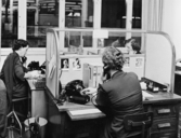 Telefoncentralen. De ingående samtalen sköts här av Gunnel Lindgren
och Inger Hoffsten (när- mast). Fönster åt Klara Norra Kyrkogata.