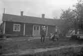 Familj framför torp, 1920-tal