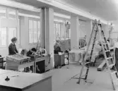 Reparations- och målningsarbeten. Till vänster rörposten. Fönster
åt gården.