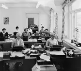 I det stora skrivrummet expedieras de kuvert, som av postverkets
tryckeri används för utsändande av beställda häften. Här utskrivs
också de olika debiteringsbeskeden samt adressändringar. Från detta
rum ser man genom expeditionen bort till avdelningsföreståndarens
rum. Fönster åt Vasagatan.