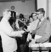 Första kontoutdraget överlämnas till herr Malmrén av tf
girobok-föringschefen överkontrollör Gillis Schreiber. Fru Inga
Malmrén ser på.