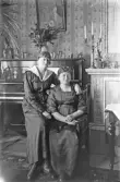 Två kvinnor framför pianot i finrummet, 1920-tal