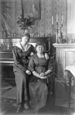 Två kvinnor framför pianot i finrummet, 1920-tal