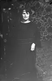 Kvinna i mörk klänning och pannband, 1920-tal