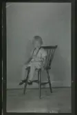 Porträtt av ett barn, sittande på en pinnstol