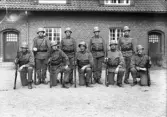 Foto av en grupp meniga med hjälmar och gevär, på kaserngården, I 11.