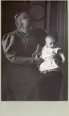 Porträtt av Sally Maria, troligen Rettig i knät på en kvinna, född den 12 okt. 1894 ?? 8 månader gammal (enligt text baksida kort).