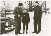 Polisassistent Lennart Johansson med sonen Roger och polisassistent Rune Ängbom en vintrig dag, ca 1958.