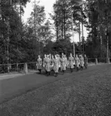 Svenska Flaggans dag 1943. 
Ett antal kvinnor i någon sorts uniform tågar in på Värendsvallen.