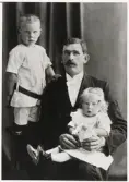 Poliskonstapel Johan Magnus Ljungberg, Vislanda, med två av hans barn, 1914.
Ateljéfoto.