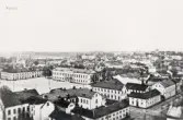Vy från domkyrkotornet över stortorget, Växjö, med bl a residenset, mot nordväst. I bakgrunden skymtar man fängelset och Kristinebergs bryggeri. Ca 1900.
Vykort efter fotografi.