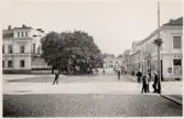 Kungsgatan mot söder i korsningen mot Storgatan, cirka 1926. I fonden syns järnvägsstationen. Till höger, i korsningen skymtar en polis i sommaruniform.