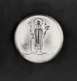 Knapp, Växjö stadsvapen med S:t Sigfrid, i mässing, för Växjö poliskår.
Trol. tillverkad efter 1939 och använd fram till ca 1965.