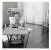 Fotografi på Per-Olov sittande i en barnstol i Lilla Källbäck.