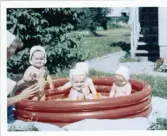 Fotografi på en grupp barn som badar i en liten uppblåsbar pool under uppsikt av en barnsköterska vid Lilla Källbäck.