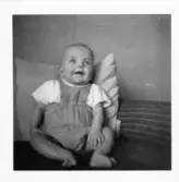 Fotografi på Lars som sitter mot en kudde.