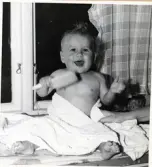 Fotografi på Bengt-Åke efter ett bad och med en borste i handen och badlakan om sig.