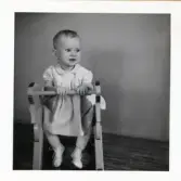 Fotografi på flickan Ingegärd sittande på en gunghäst, troligen vid Lilla Källbäck.