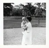 Fotografi på en barnsköterska med Eva 1år i sin famn troligen vid Lilla Källbäck.