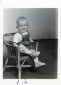 Fotografi på Mikael 1 år, sittande i en liten korgstol.