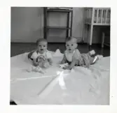 Fotografi på Ulf och Gina liggandes på en filt med leksaker i Lilla Källbäck.